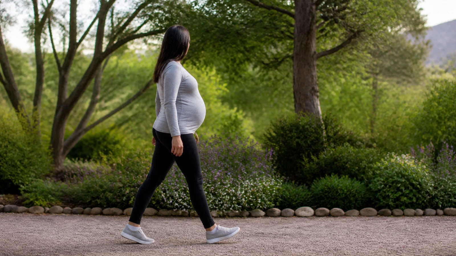Femme enceinte adulte marchant doucement dans un jardin