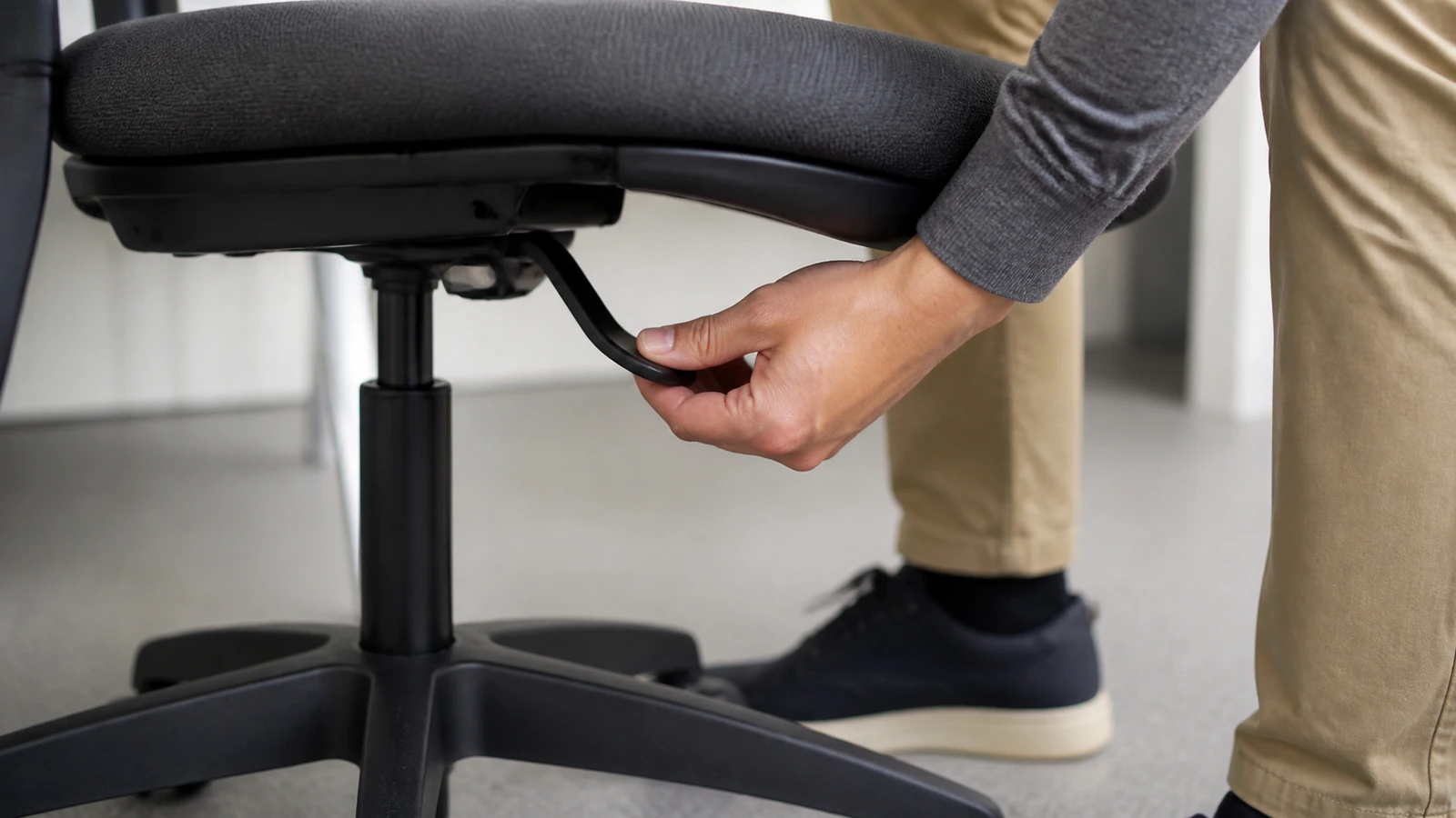 Main réglant sobrement la hauteur d’une chaise